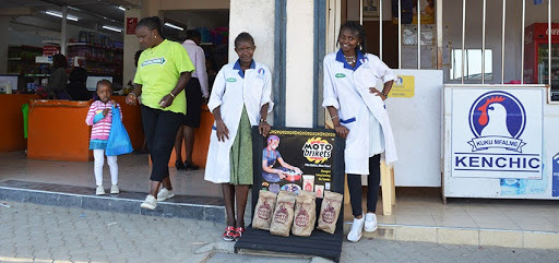 Two young women that work with a BrightGreen Renewable Energy's distributor with the new product display shelf. Nairobi, Kenya. Photo: Erika Desmond